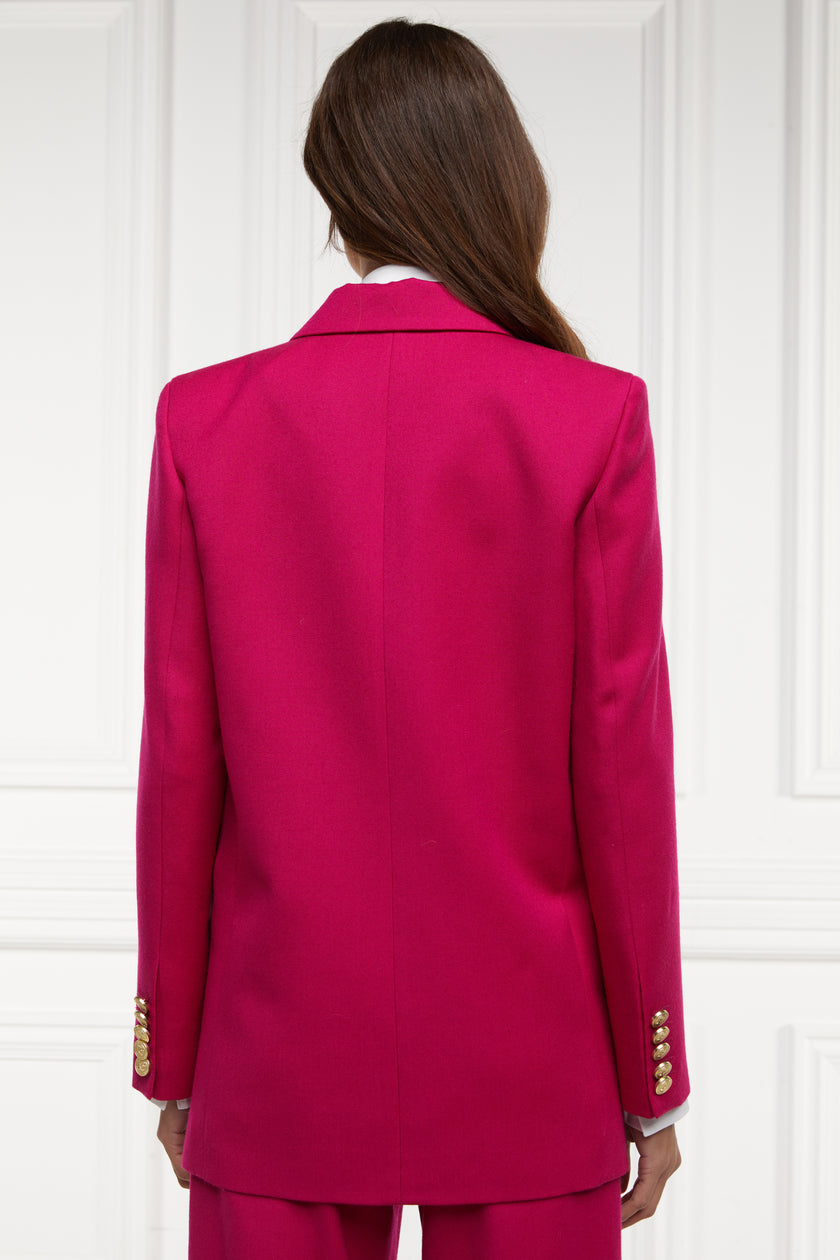 back of longline double breasted wool blazer in hot pink tailor made in britain with relaxed fit welt pockets and gold buttons on the front and cuffs