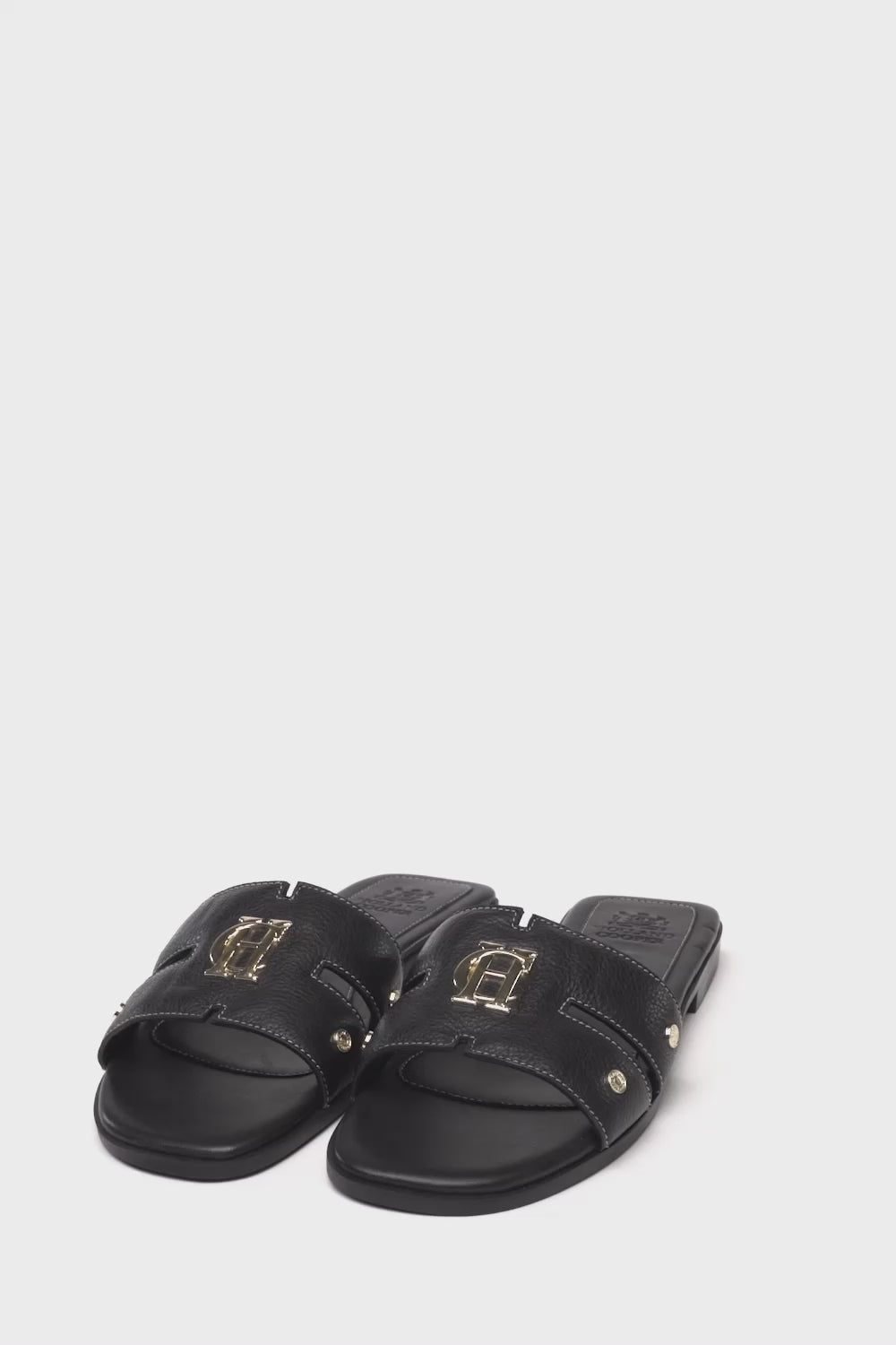 360 video of black leather sliders with contrast white stitching, a black leather sole and gold hardware