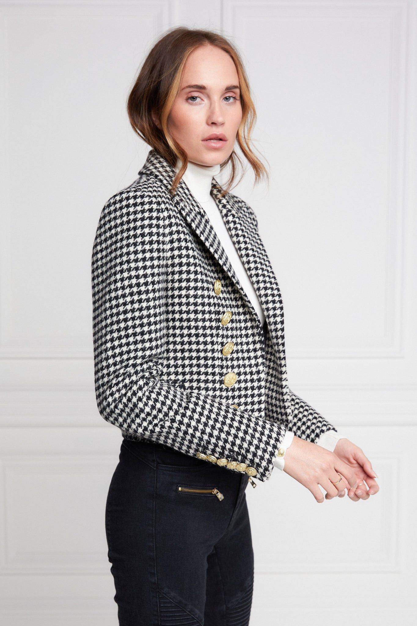 British made tailored cropped jacket in black and white houndstooth with welt pockets and gold button detail down the front and on sleeves