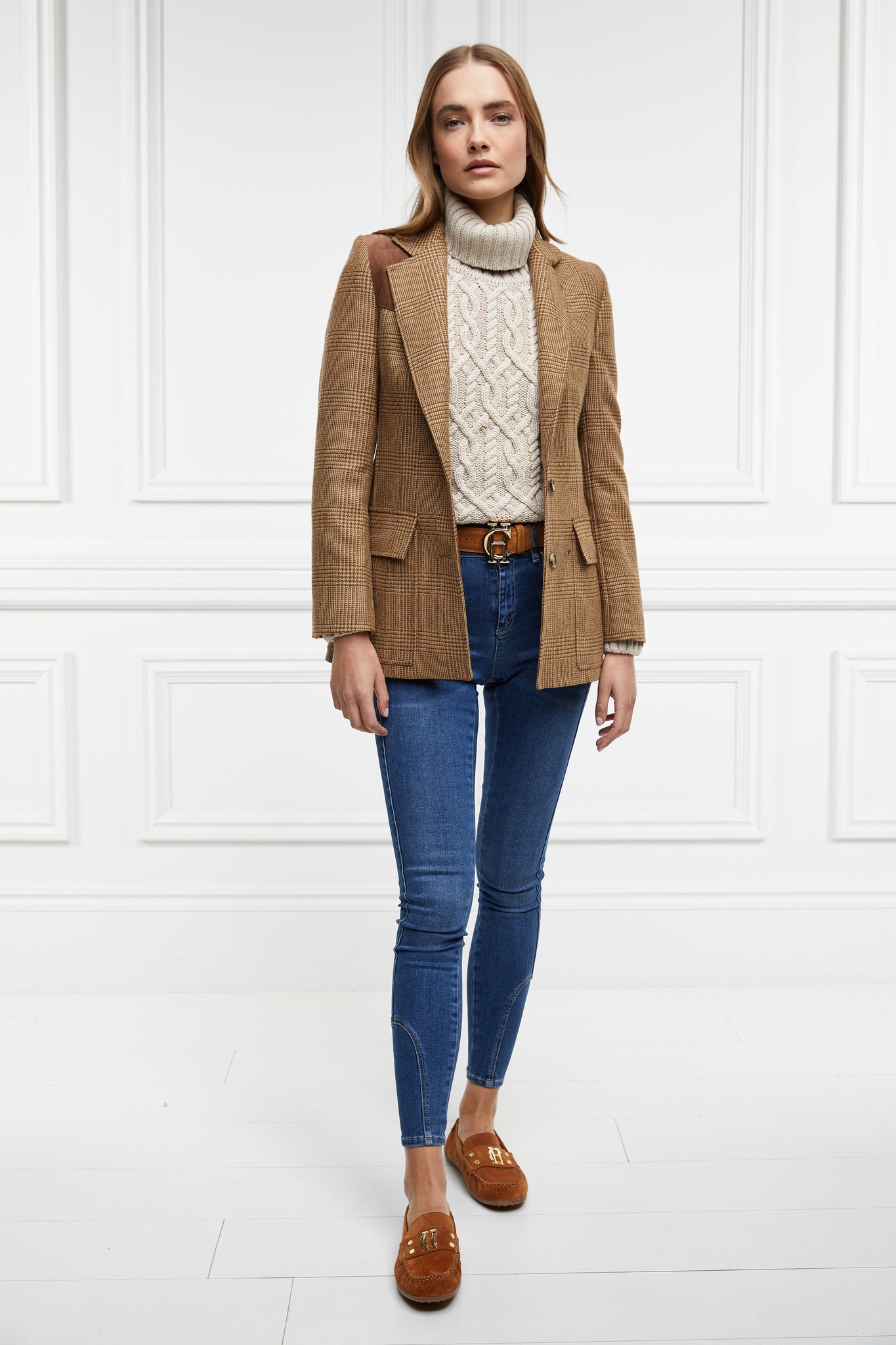 classic tan suede loafers with a leather sole and top stitching details and gold hardware paired with denim skinny jeans, cream cable knit jumper, tawny blazer and brown leather belt