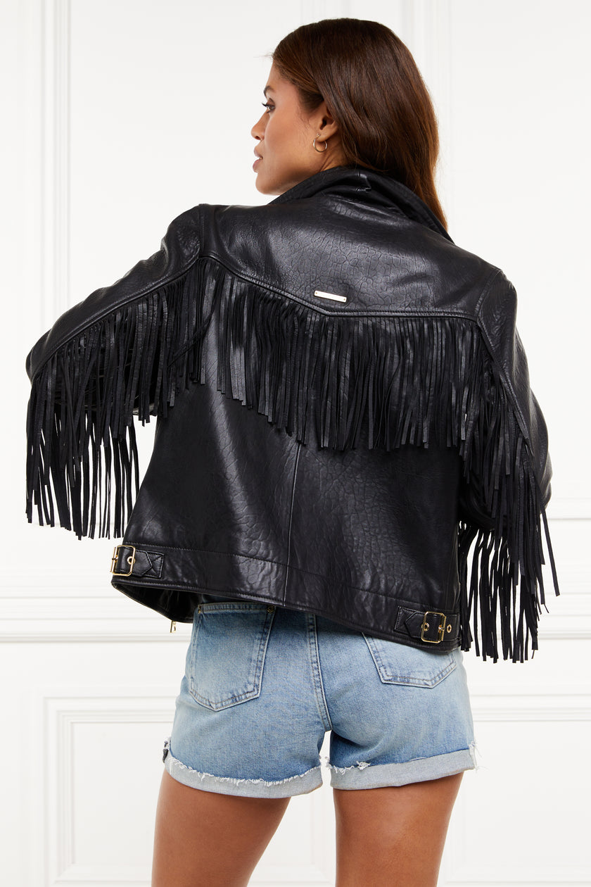 back of womens leather biker jacket in black with fringing along the back and sleeves detailed with golf zips and small shield badge on arm