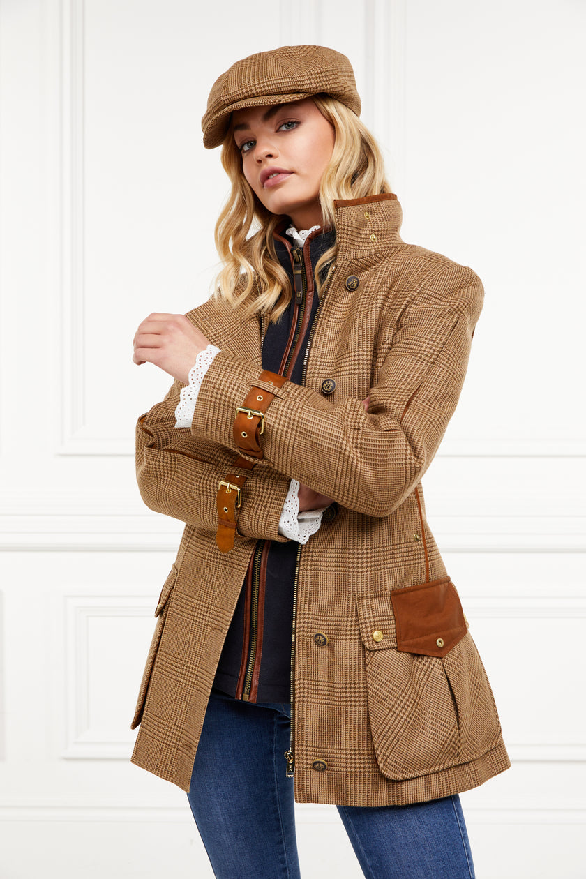 Woman in tan brown tartan tweed field coat and baker boy cap