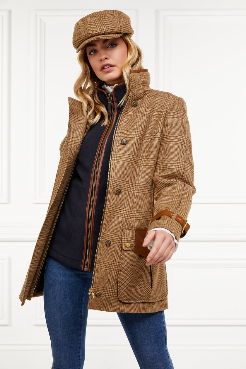 Woman in tan brown tartan tweed field coat and baker boy cap