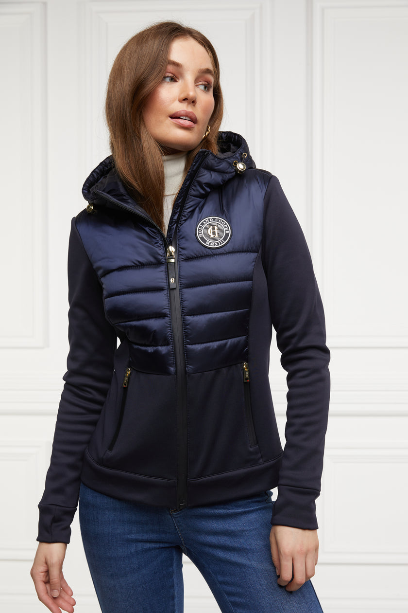 hooded hybrid jacket in navy with jersey panels on the waist and sleeves and Sorona eco down fill on hood front and back body panels finished with rubbed zip fastening in black and two side pockets with the same zip fastenings