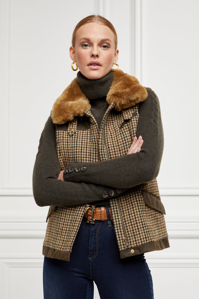 Chunky knit roll neck jumper in fern green layered under a country gilet in hales green tweed with a shearling collar