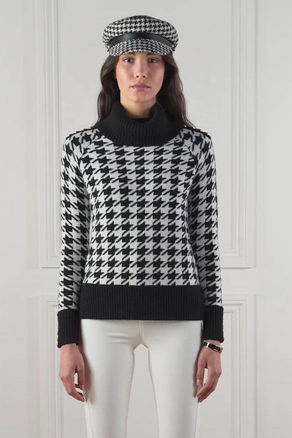 a classic black and white houndstooth jumper with contrast black cuffs, roll neck and split ribbed hem with gold button detail on the cuffs and collar