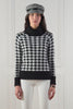 a classic black and white houndstooth jumper with contrast black cuffs, roll neck and split ribbed hem with gold button detail on the cuffs and collar