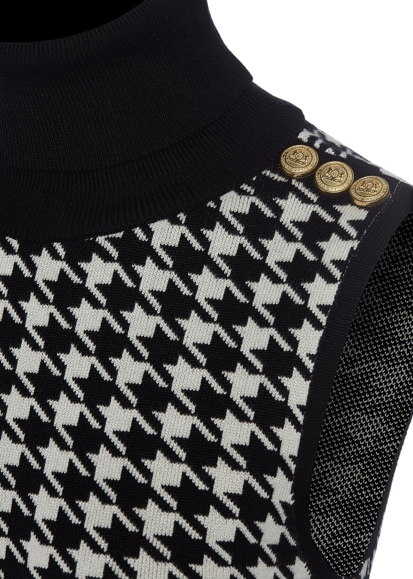 gold button detail on shoulders of womens black and white houndstooth sleeveless mini dress with black contrast arm holes roll neck and hem