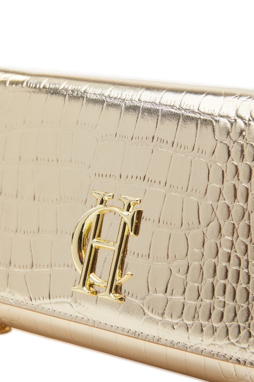 detail shot womens gold croc embossed leather clutch bag with gold hardware