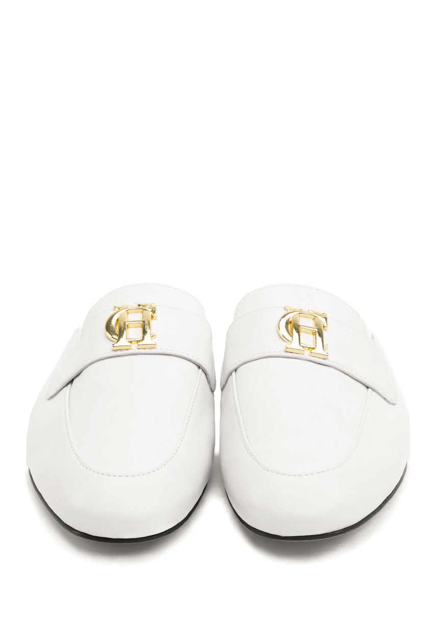 Front shot of white leather backless loafers with a slightly pointed toe and gold hardware to the top